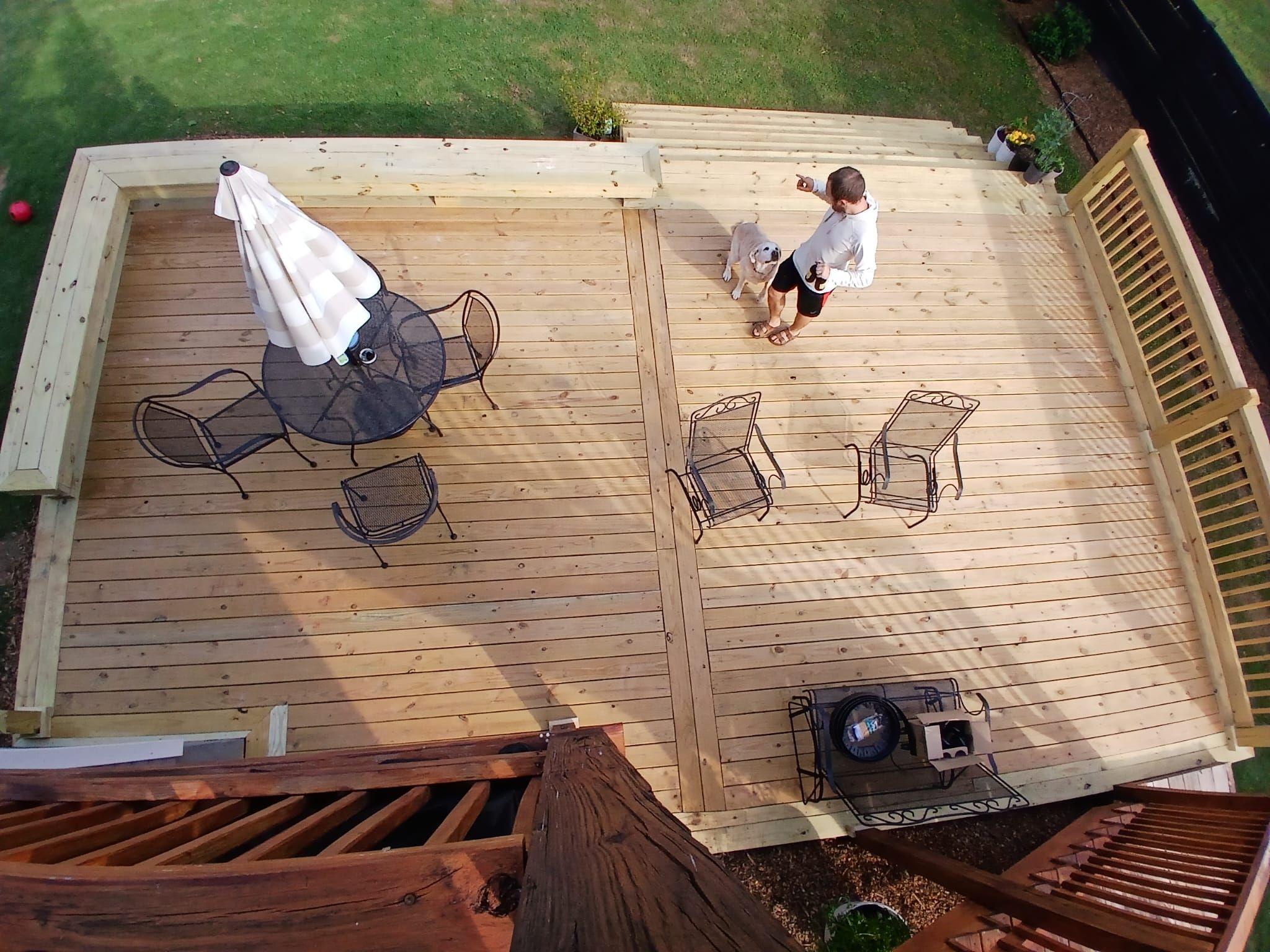 Bird's-eye view of a pine deck with a patio table, chairs and an umbrella