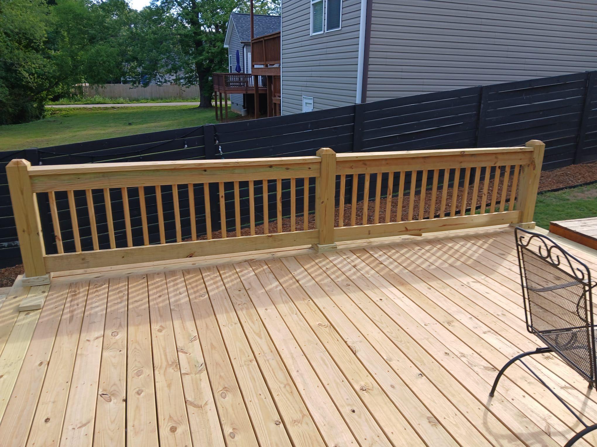 Pine deck railing with square balusters overlooking the backyard